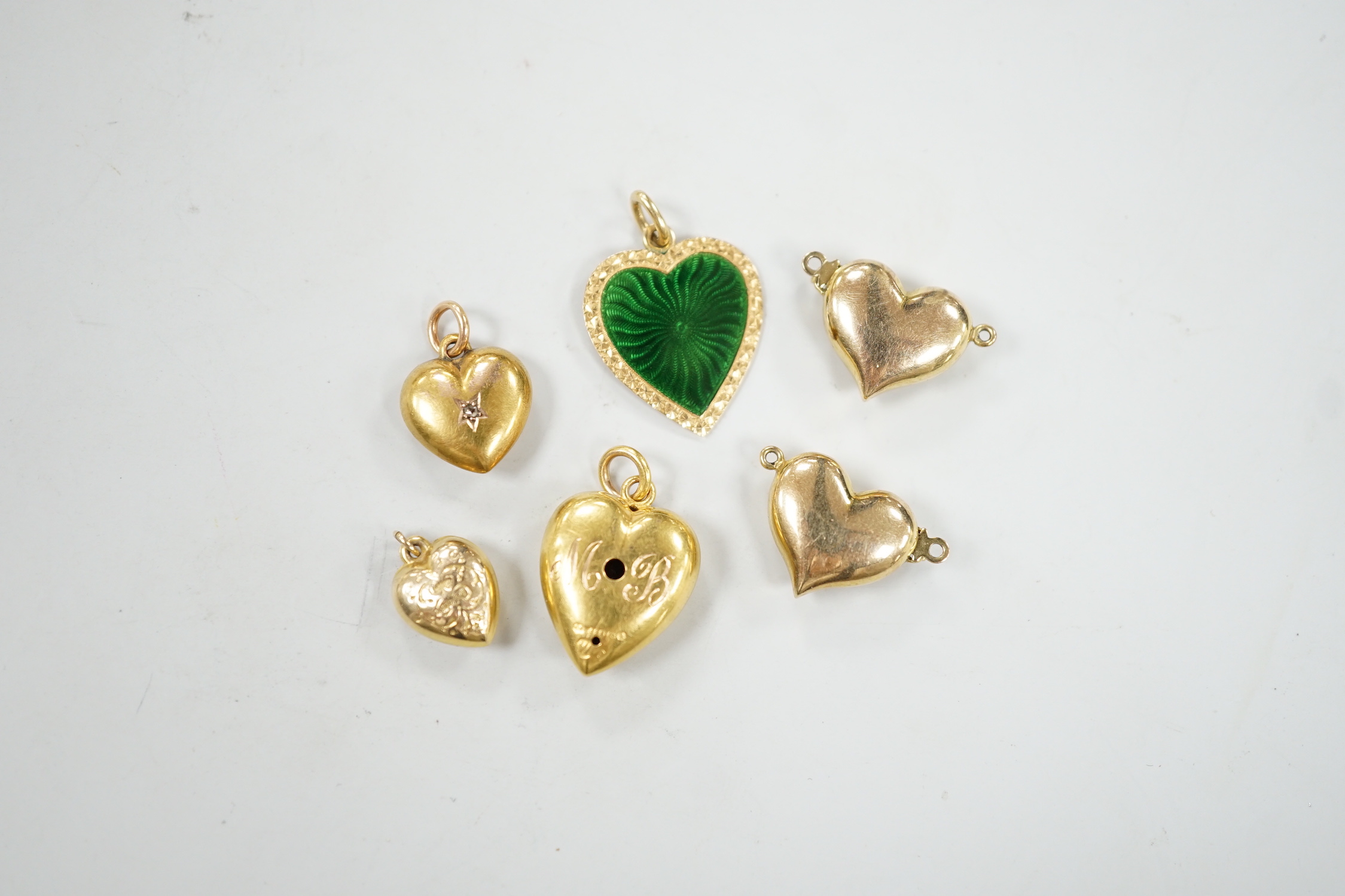 Two late Victorian 15ct and single stone diamond set heart pendants, largest 19mm, gross weight 3.1 grams, four other yellow metal heart shaped pendants including one with green enamel.